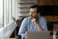 Thoughtful businessman in glasses looking at window from workplace Royalty Free Stock Photo