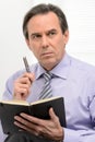 Thoughtful businessman. Mature businessman sitting with a note p