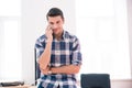 Thoughtful businessman talking on the phone in office Royalty Free Stock Photo