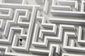 Thoughtful businessman trying to find way out of maze, above view