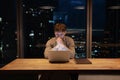 Thoughtful businessman working on laptop at night, developing project strategy Royalty Free Stock Photo