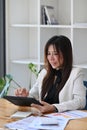 Thoughtful businesswoman checking financial data on digital tablet. Royalty Free Stock Photo