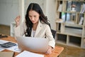 A thoughtful businesswoman looking at her laptop with a serious face, and working at her desk Royalty Free Stock Photo