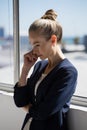 Thoughtful businesswoman looking lown while standing by window