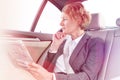 Thoughtful businesswoman with newspaper sitting in car Royalty Free Stock Photo