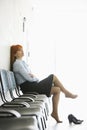 Thoughtful businesswoman sitting with legs crossed on chair in office Royalty Free Stock Photo