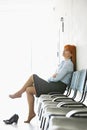 Thoughtful businesswoman sitting with legs crossed on chair in office Royalty Free Stock Photo