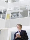 Thoughtful Businesswoman With Takeaway Coffee Cup In Office