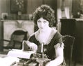 Thoughtful businesswoman with typewriter at desk in office