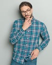 thoughtful casual man in shirt with glasses touching chin and thinking Royalty Free Stock Photo