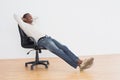 Thoughtful casual man sitting on office chair in empty room Royalty Free Stock Photo