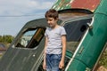 Thoughtful caucasian teenage standing on the grass in countyside in summer day with serious face expression, a retro car is on Royalty Free Stock Photo