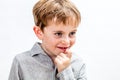 Thoughtful cheeky kid scratching his chin to imagine or conspire