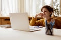 A thoughtful child listens to a teacher in an online class