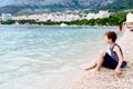 Thoughtful child sitting on the beach Royalty Free Stock Photo