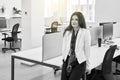 Thoughtful confident caucasian business woman or manager alone in modern office. Black and white. Royalty Free Stock Photo