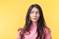 Thoughtful confused woman looking away isolated over yellow background