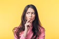 Thoughtful confused woman looking away isolated over yellow background