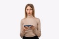 Thoughtful confused young blond woman holding her smart phone. Technology, youth and communication concept Royalty Free Stock Photo