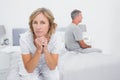 Thoughtful couple sitting on different sides of bed having a dis Royalty Free Stock Photo