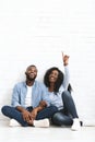 Thoughtful couple sitting on floor at new house, looking up Royalty Free Stock Photo