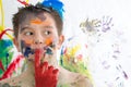Thoughtful creative little boy covered in paint