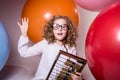 Thoughtful curly teen girl in glasses with wooden abacus on the Royalty Free Stock Photo