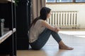 Thoughtful depressed young female sitting on floor hugging knees Royalty Free Stock Photo