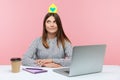 Thoughtful dreamy woman office worker in striped shirt holding model of paper house on head, dreaming about own safety apartment Royalty Free Stock Photo