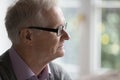 Thoughtful elder senior pensioner man in glasses looking at window Royalty Free Stock Photo