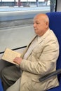 The thoughtful elderly man reads the book in the electric train car Royalty Free Stock Photo