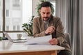 Thoughtful entrepreneur analyzing document while working at the office desk Royalty Free Stock Photo