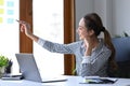 Thoughtful entrepreneur sitting and her workplace and writing new idea on sticky notes. Royalty Free Stock Photo