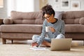 Thoughtful ethnic woman doing paperwork at home