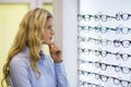 Thoughtful female customer selecting spectacles