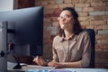 Thoughtful female interior architect or designer working on a project, using computer while sitting at the desk in her Royalty Free Stock Photo