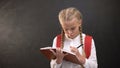 Thoughtful female kid with rucksack doing homework, having an idea, education