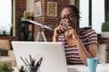 Thoughtful freelancer talking on smartphone with client, rubbing chin