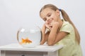 Thoughtful girl dreaming and looking at goldfish Royalty Free Stock Photo