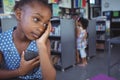 Thoughtful girl looking away while holding mobile phone Royalty Free Stock Photo