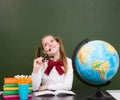 Thoughtful girl looking up near empty chalkboard Royalty Free Stock Photo