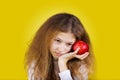 Thoughtful girl with red apple near her head