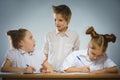Thoughtful girls and little schoolboy on gray background. school concept Royalty Free Stock Photo