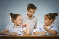 Thoughtful girls and little schoolboy on gray background. school concept Royalty Free Stock Photo