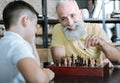 Thoughtful granddad teaching kid chess game Royalty Free Stock Photo