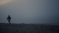 Thoughtful guy looking sea landscape at misty morning. Man walking on beach Royalty Free Stock Photo