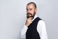 Thoughtful, Handsome businessman with beard and handlebar mustache looking at camera and thinking.