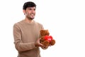 Thoughtful happy Persian man smiling while giving teddy bear wit Royalty Free Stock Photo