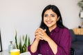 Thoughtful happy young indian business woman sitting with laptop at home table Royalty Free Stock Photo