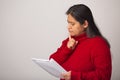 Thoughtful Hispanic Woman Inspects Notes